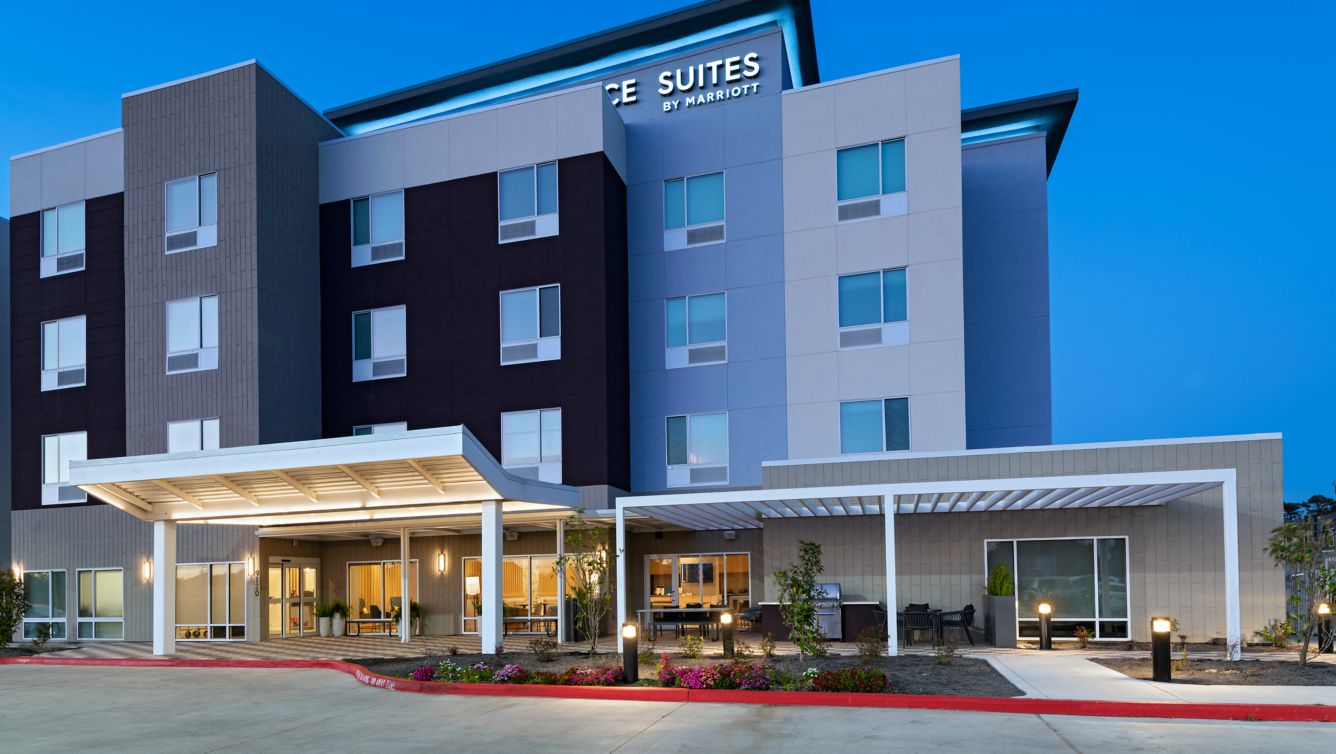 Exterior and entrance canopy of TownePlace Suites Houston Tomball at dusk